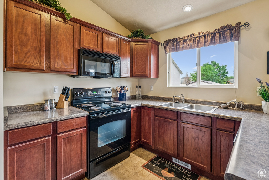 Kitchen with black appliances, vaulted ceiling, and recessed lighting