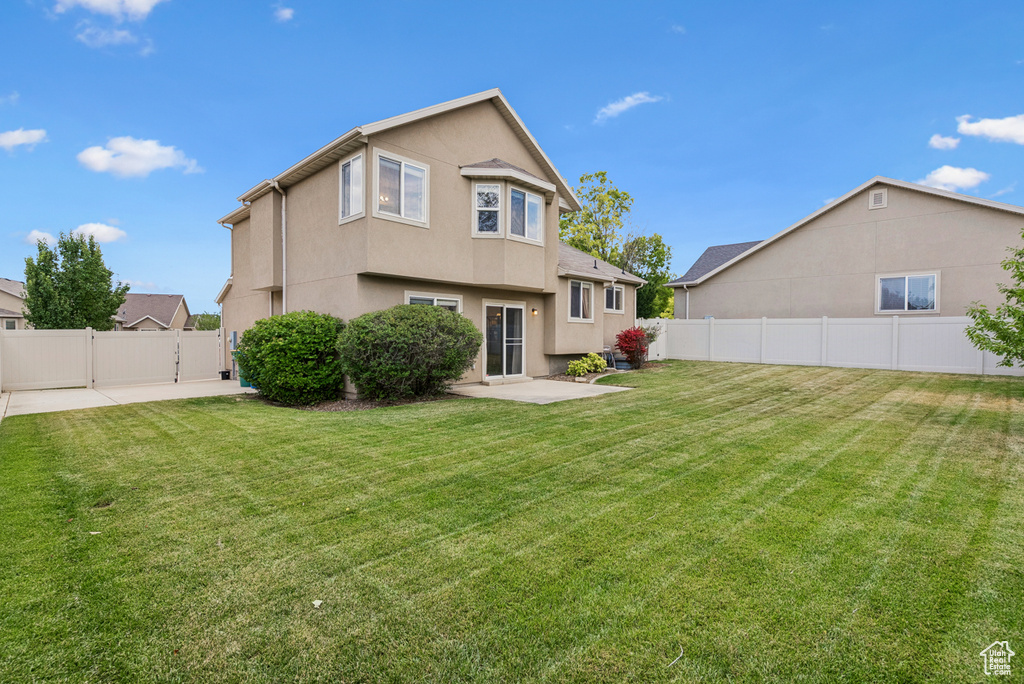 Rear view of property with a patio area, a fenced backyard, and stucco siding