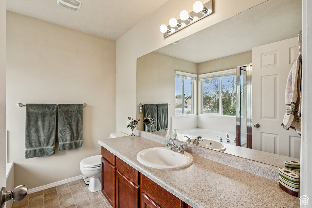 Bathroom featuring a garden tub, vanity, and an enclosed shower