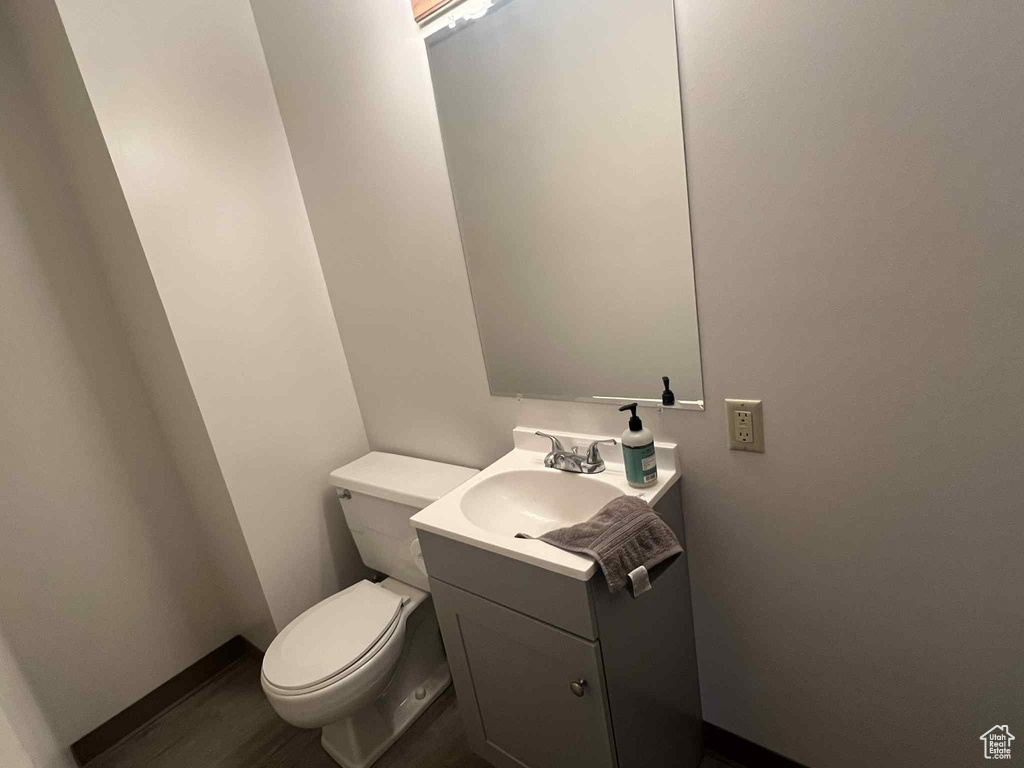 Half bath featuring vanity and wood finished floors
