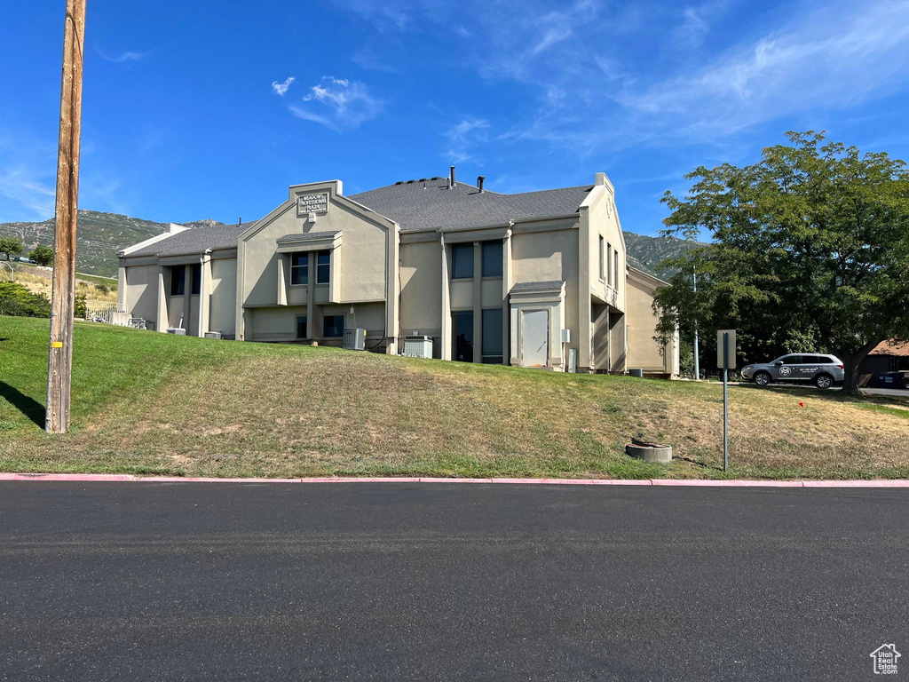 View of front facade featuring stucco siding and a front lawn