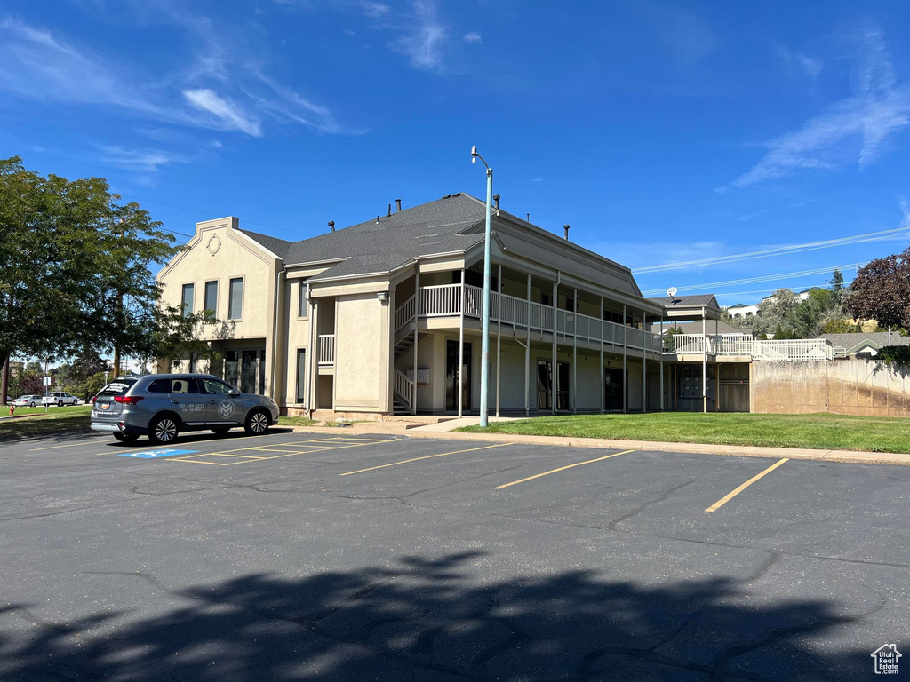 View of building exterior featuring uncovered parking and stairway