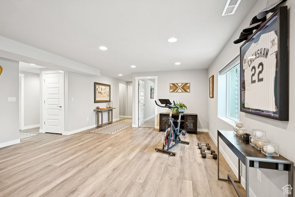 Workout room with recessed lighting and light wood-style flooring