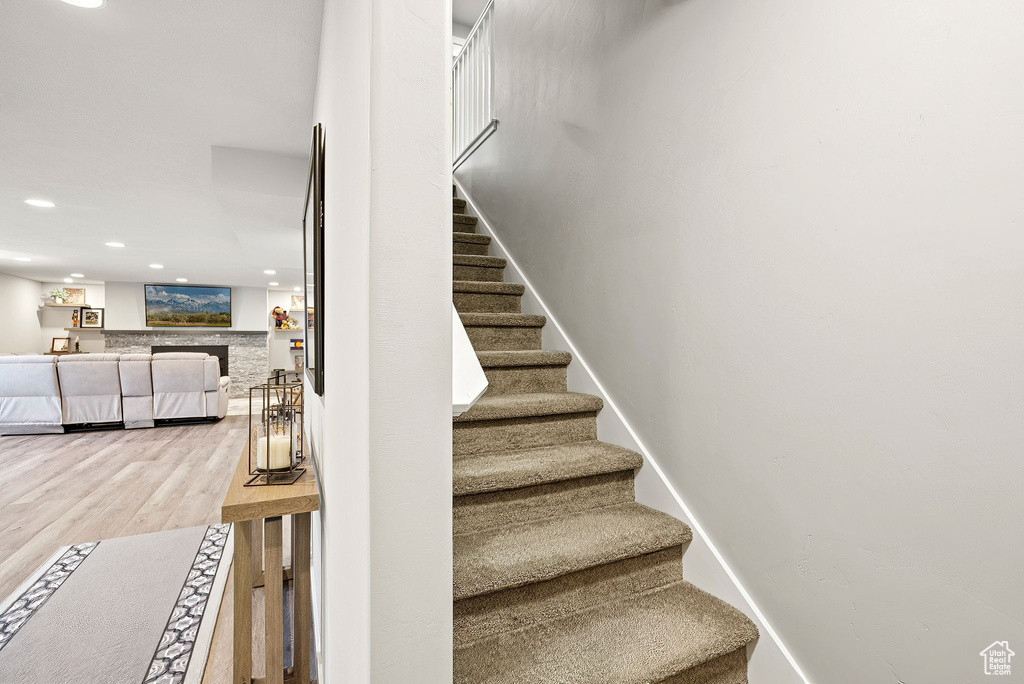 Staircase with wood finished floors and recessed lighting