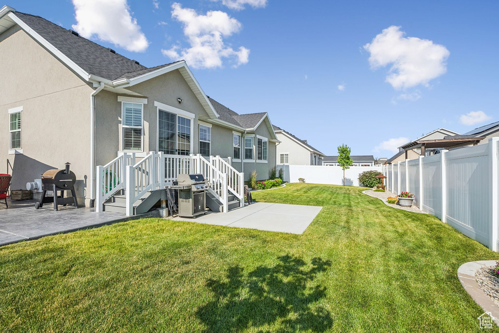 Back of property with a patio area, a fenced backyard, stucco siding, and a residential view