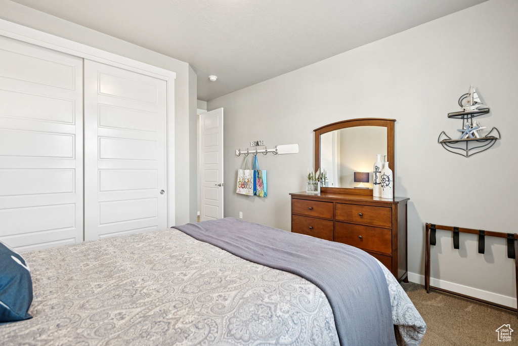 Carpeted bedroom featuring baseboards and a closet