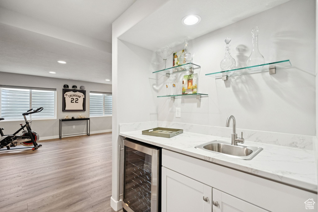 Indoor wet bar with wine cooler, light wood finished floors, and recessed lighting