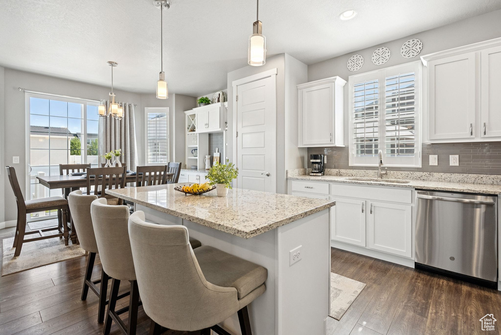 Kitchen featuring dishwasher, a kitchen island, white cabinets, tasteful backsplash, and recessed lighting