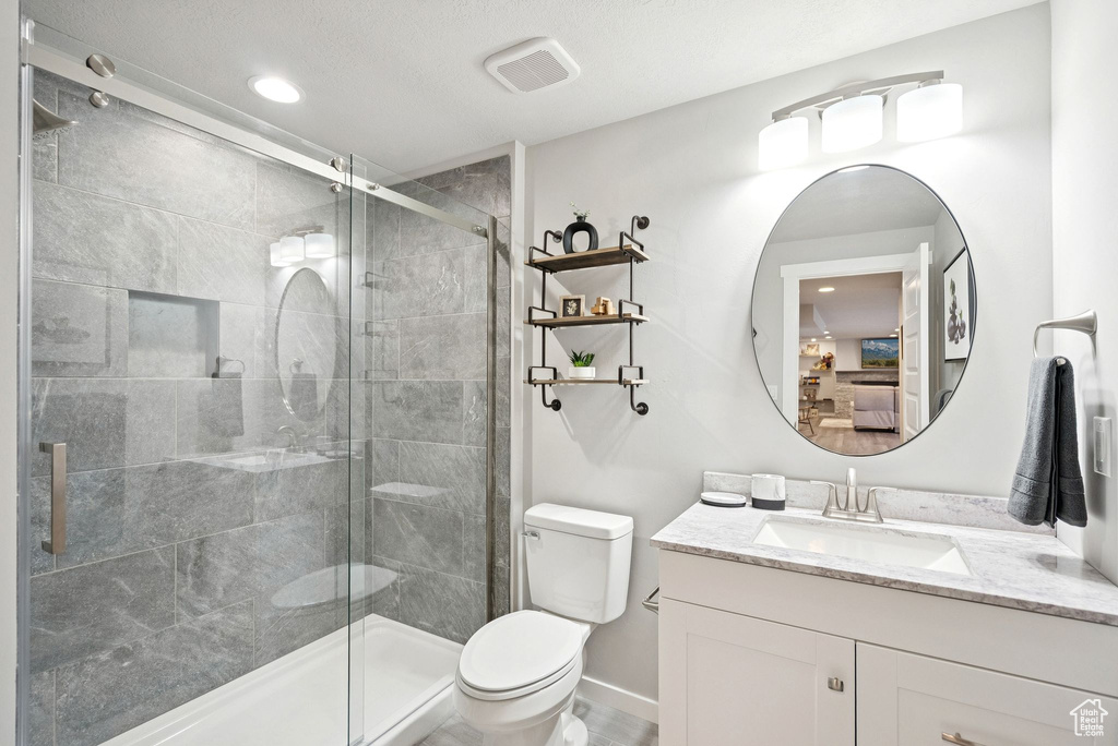 Bathroom featuring connected bathroom, vanity, a stall shower, and recessed lighting