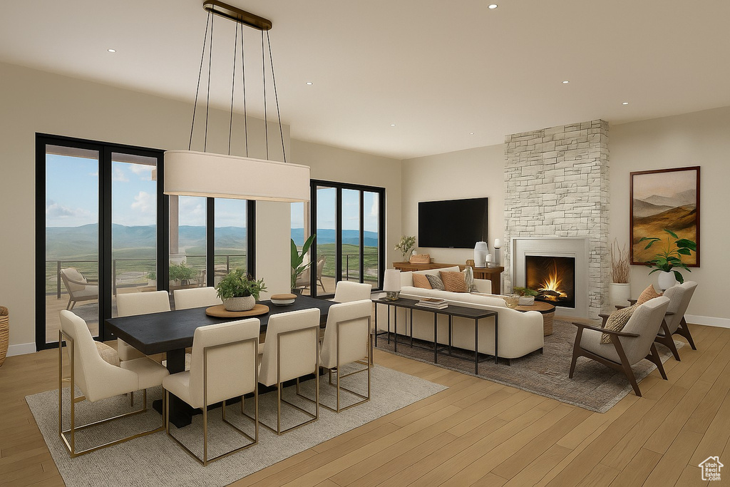 Living area with light wood finished floors, a stone fireplace, recessed lighting, and a mountain view
