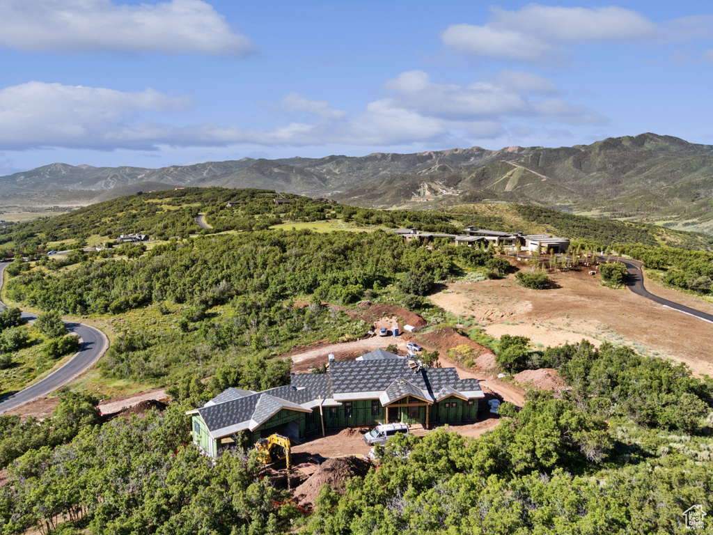 Aerial view of property and surrounding area featuring a mountain backdrop