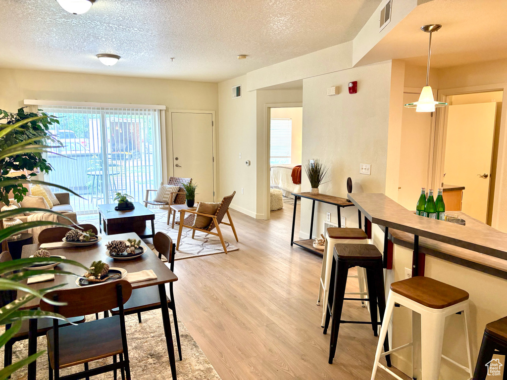 Dining room featuring light wood-type flooring and a textured ceiling