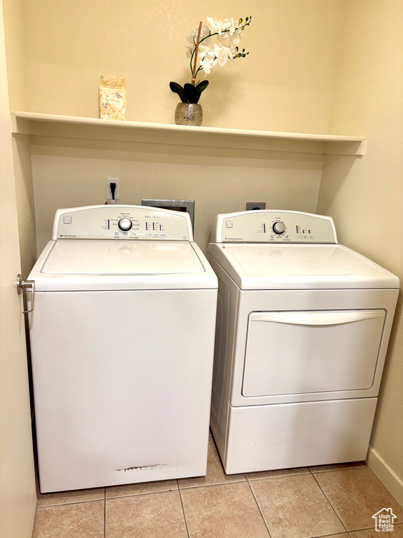Laundry area with washing machine and clothes dryer and light tile patterned floors