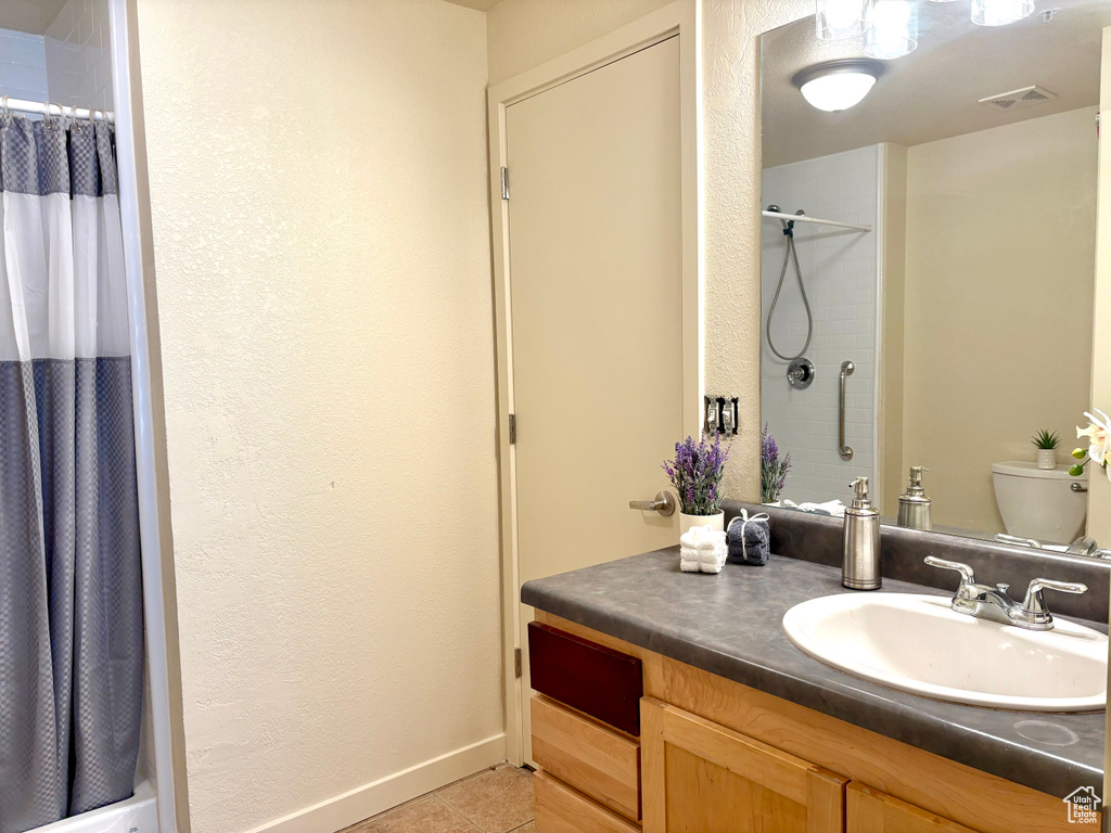 Full bath with vanity, a shower with shower curtain, and tile patterned flooring