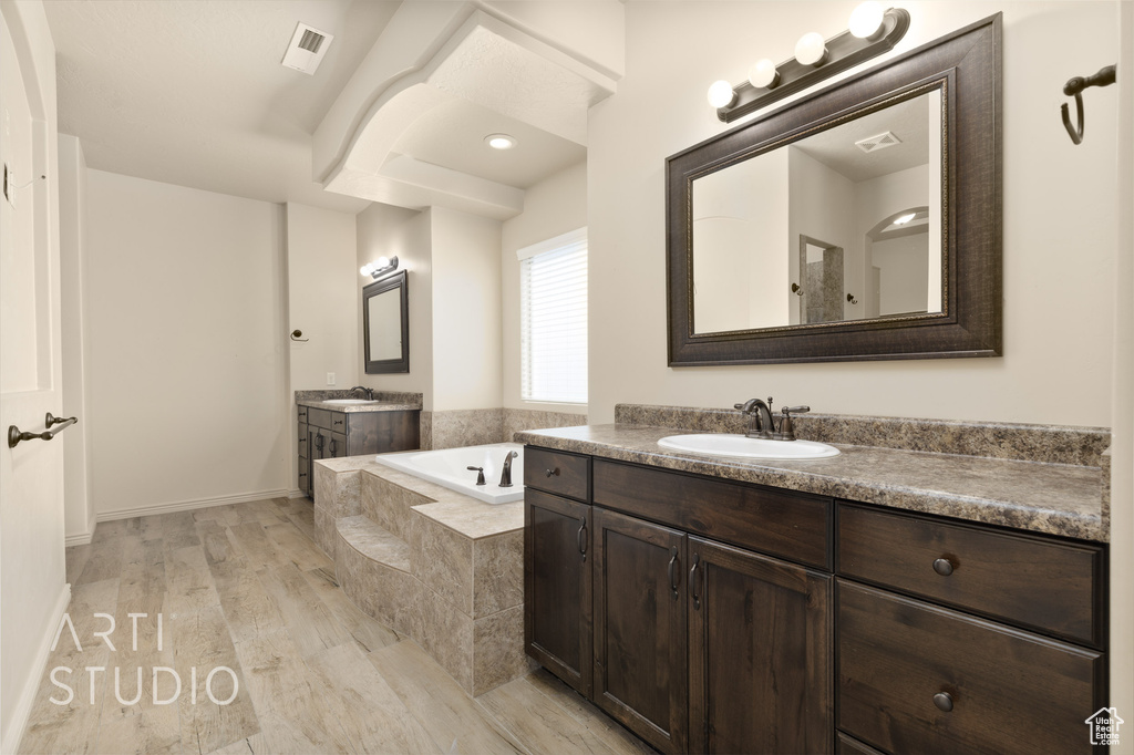 Full bath with a bath and two vanities