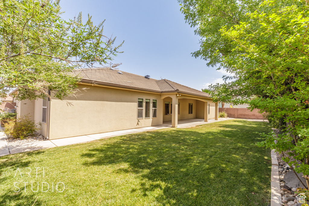 Rear view of house with stucco siding and a patio area