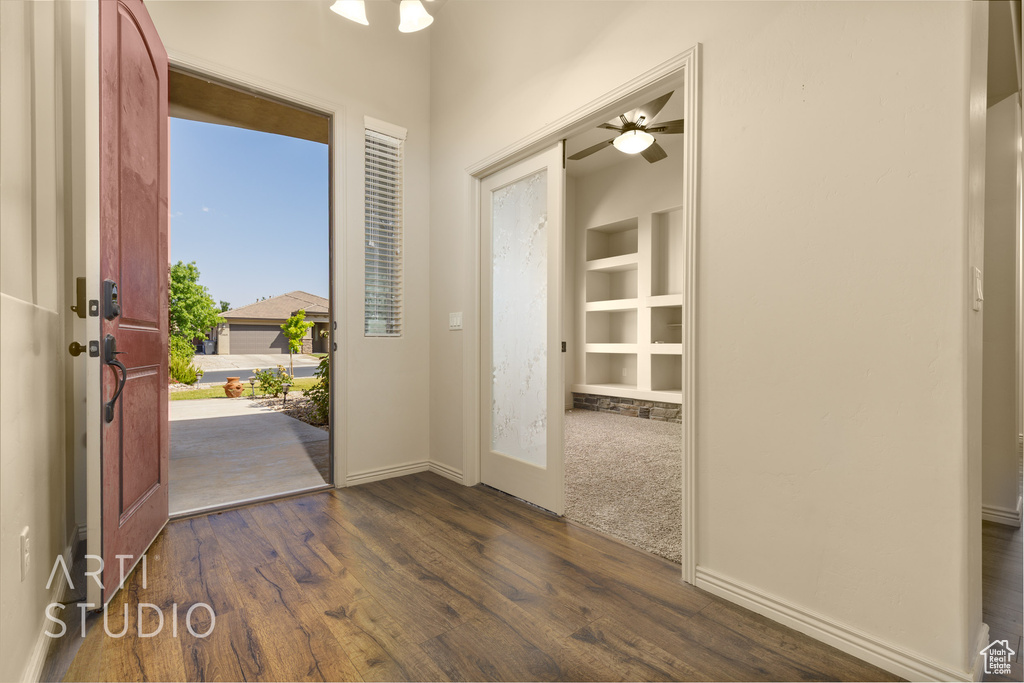 Foyer entrance with dark wood-style floors and a ceiling fan