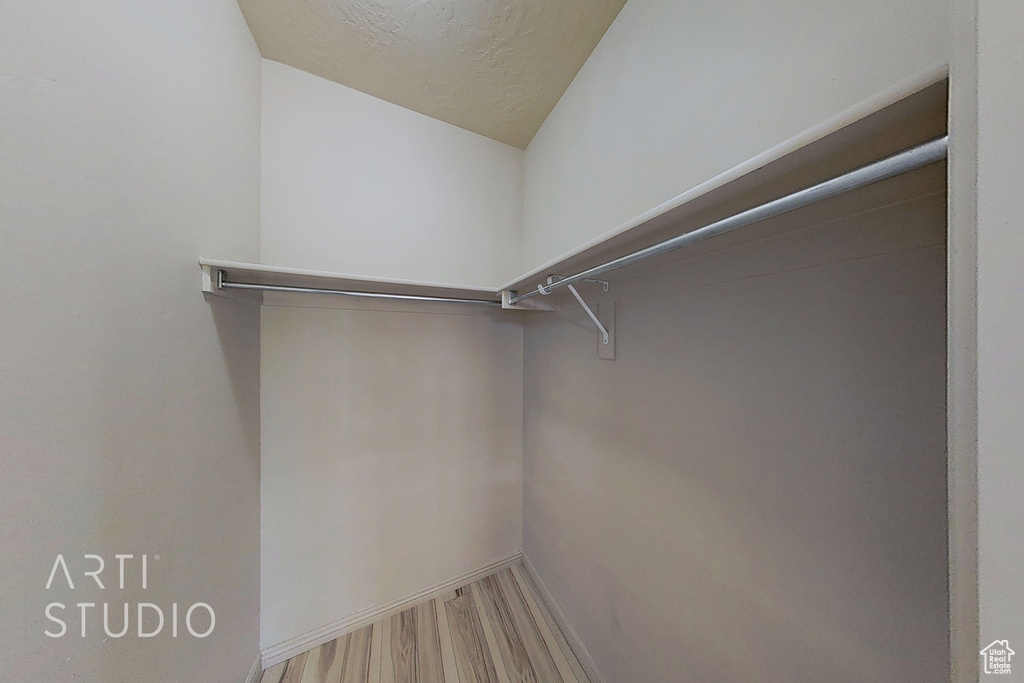Spacious closet with wood finished floors and lofted ceiling