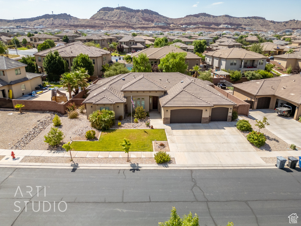 View of front facade with a residential view, stucco siding, a garage, and concrete driveway