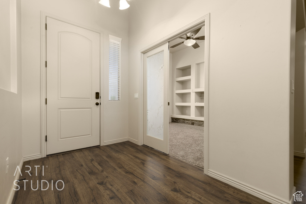 Foyer entrance with dark wood finished floors and a ceiling fan
