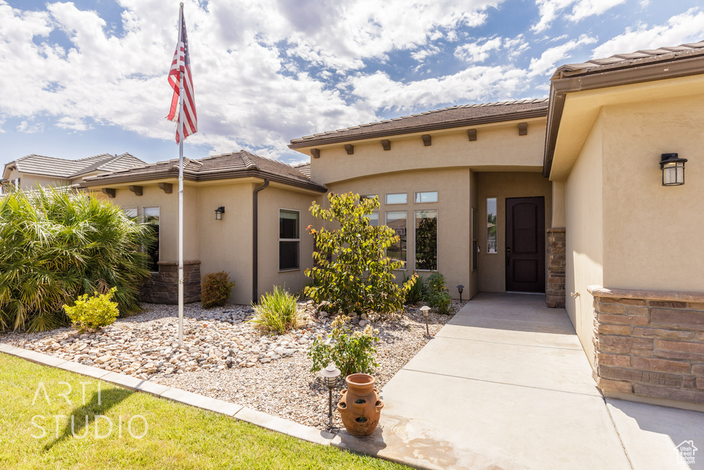 View of exterior entry featuring stucco siding and a tile roof