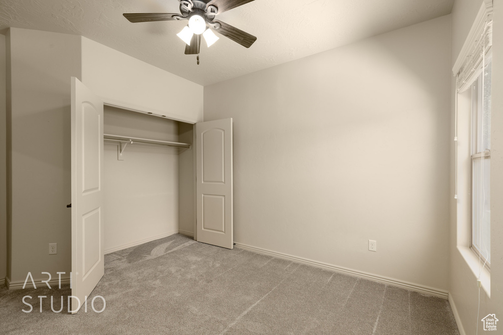 Unfurnished bedroom with carpet flooring, a closet, and a ceiling fan