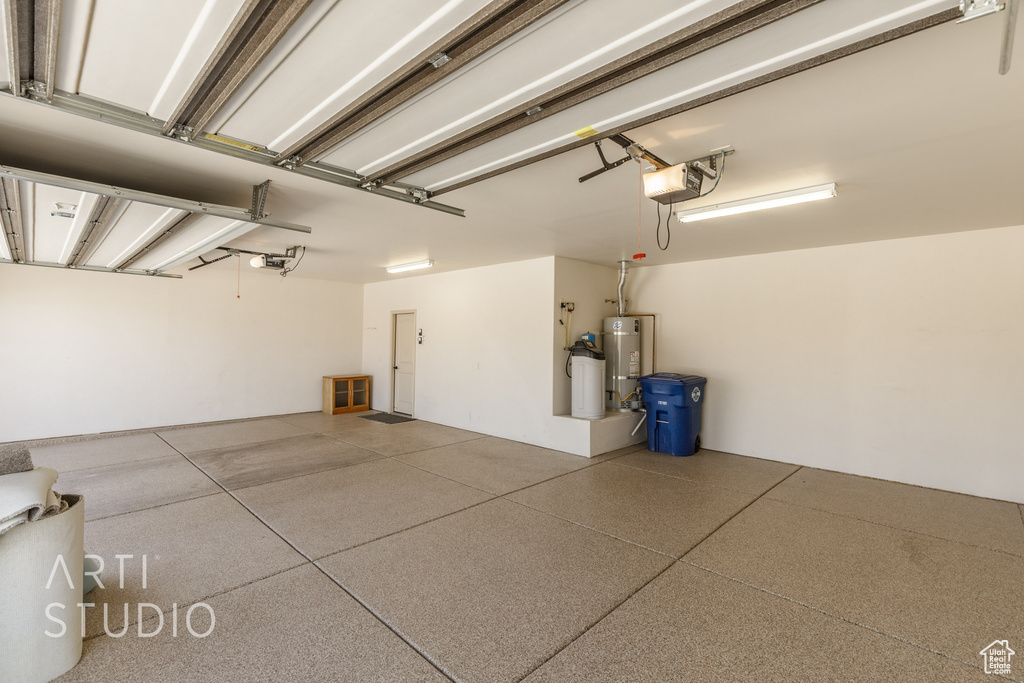 Garage featuring secured water heater and a garage door opener
