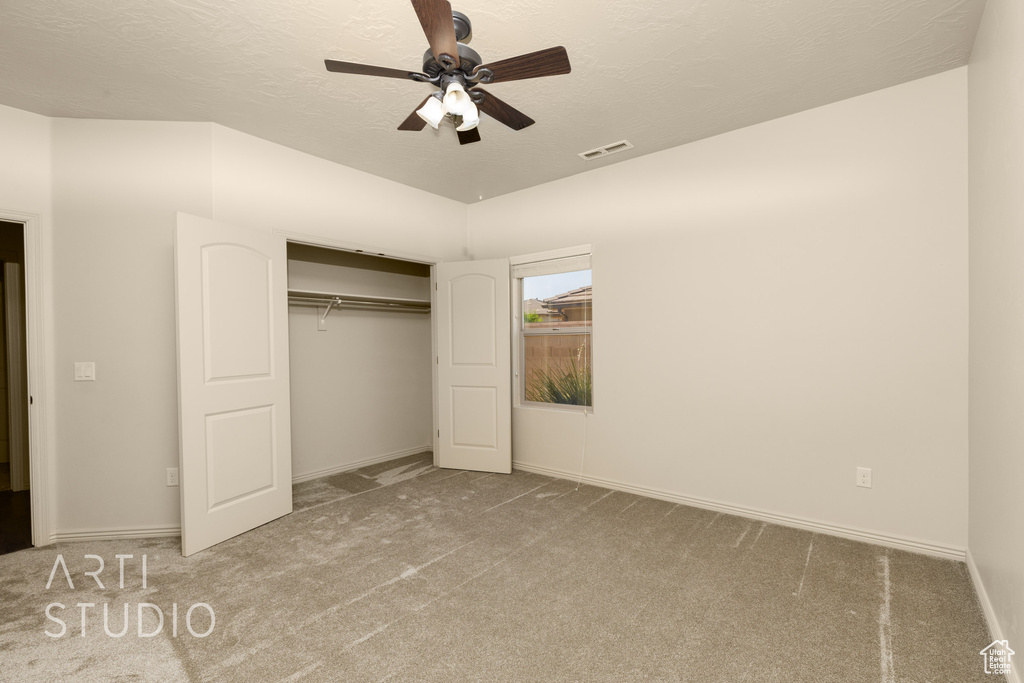 Unfurnished bedroom featuring carpet floors, a closet, a ceiling fan, and a textured ceiling