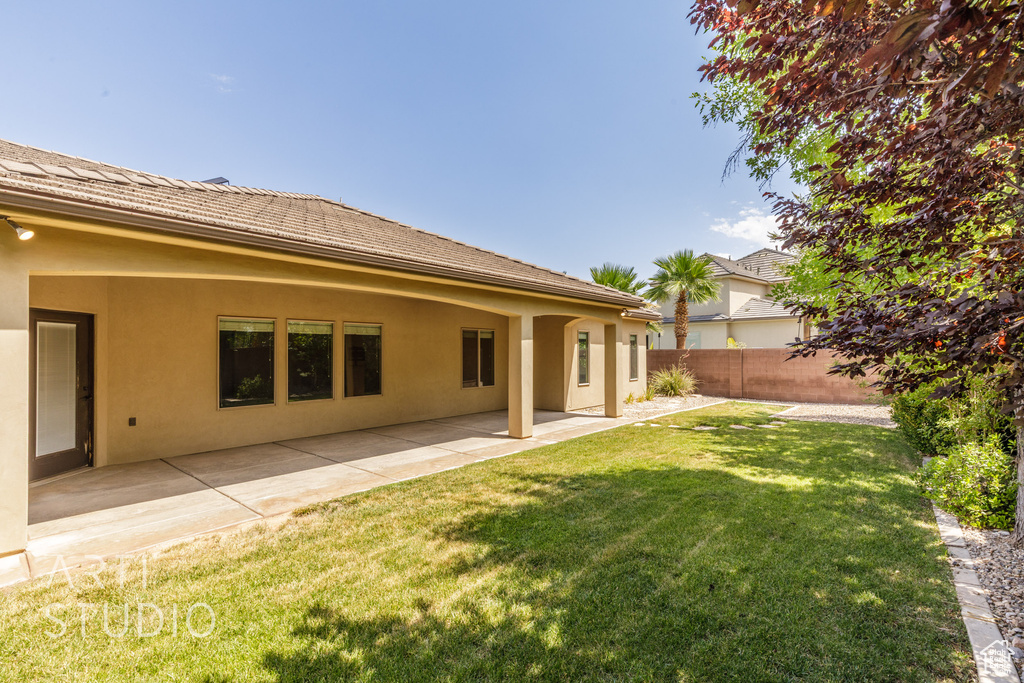 Rear view of house with stucco siding and a patio area