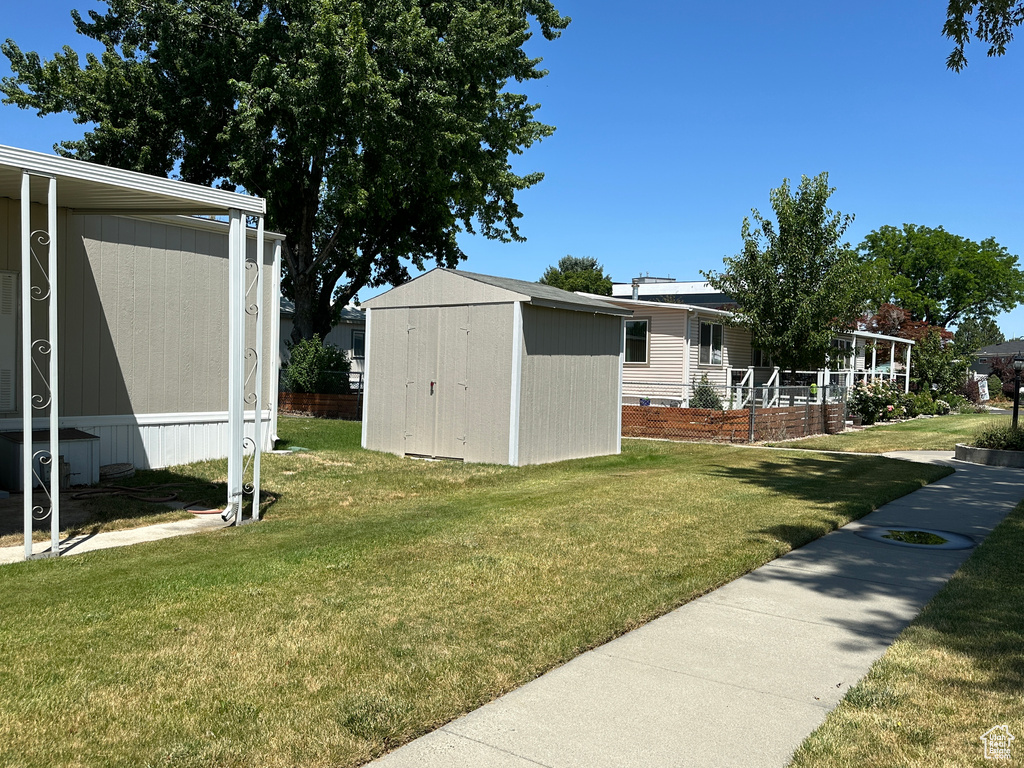 View of grassy yard with a storage unit