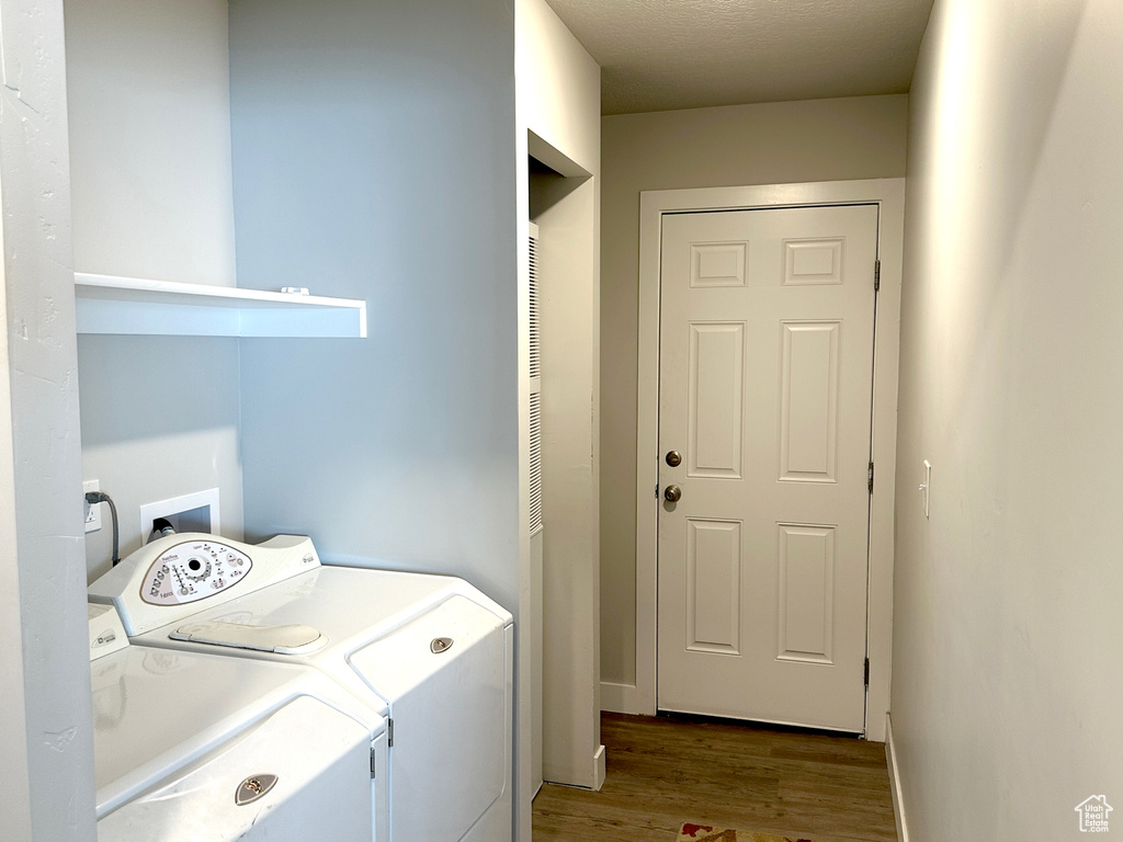 Washroom with independent washer and dryer and wood finished floors