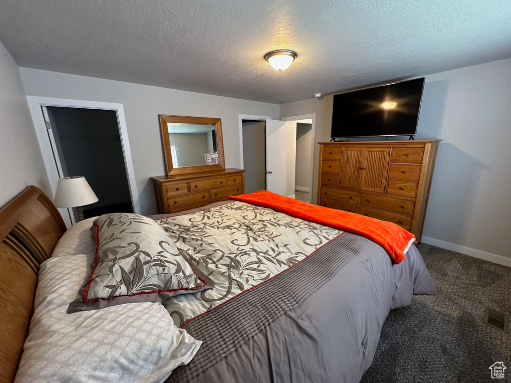 Bedroom featuring carpet and a textured ceiling