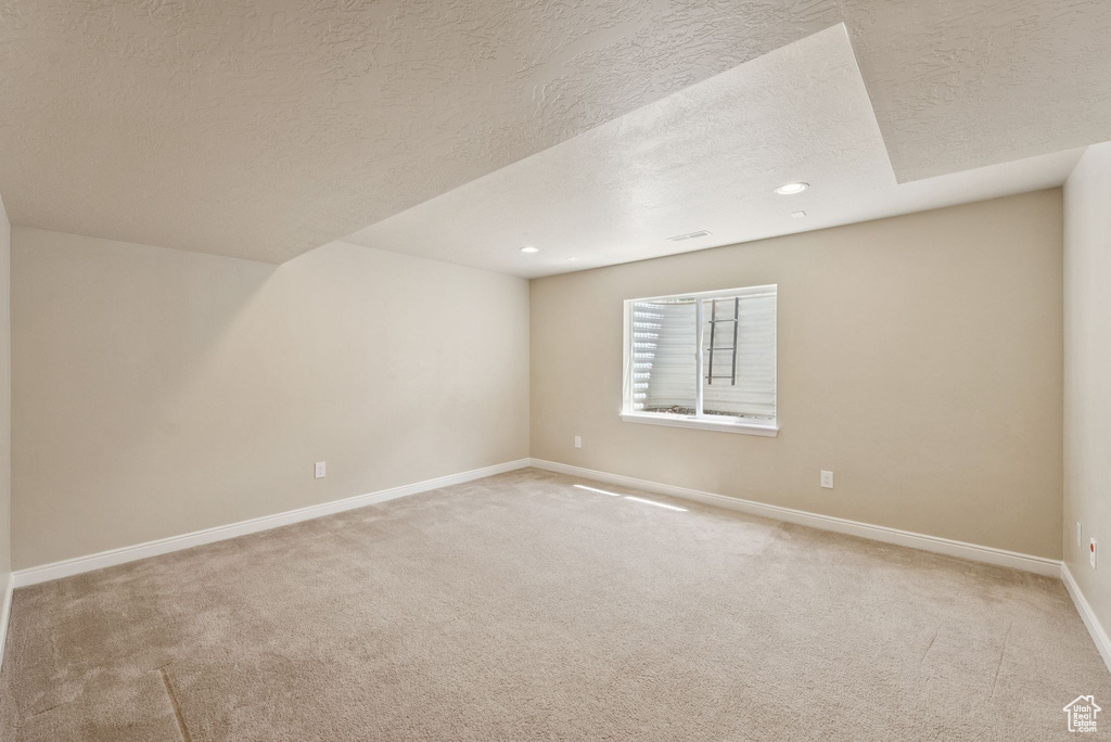Bonus room featuring light colored carpet, recessed lighting, and a textured ceiling