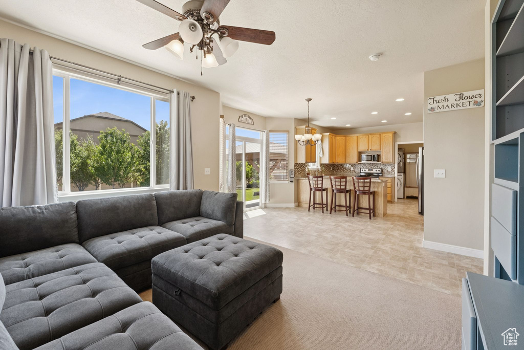 Living area featuring a ceiling fan, recessed lighting, a chandelier, and light colored carpet