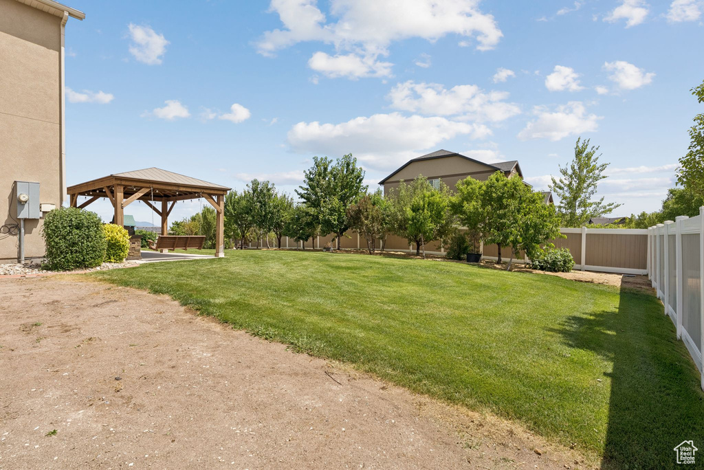 Fenced backyard featuring a gazebo