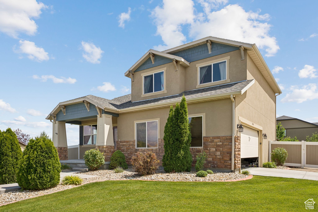 Craftsman-style house with stucco siding, stone siding, a garage, and concrete driveway