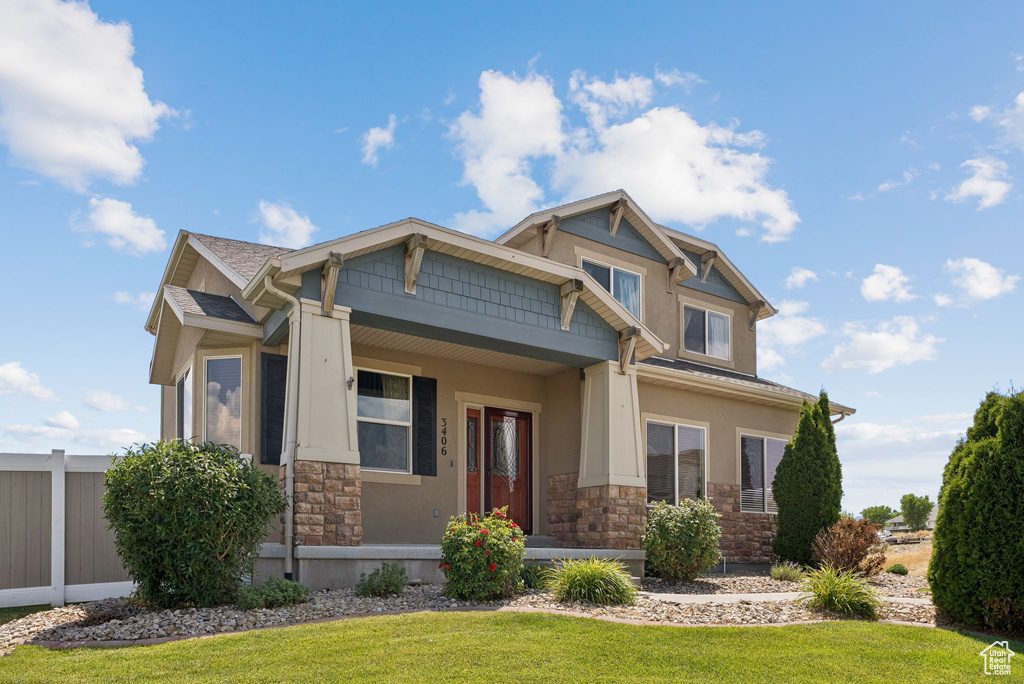 Craftsman-style house featuring stone siding, stucco siding, and covered porch