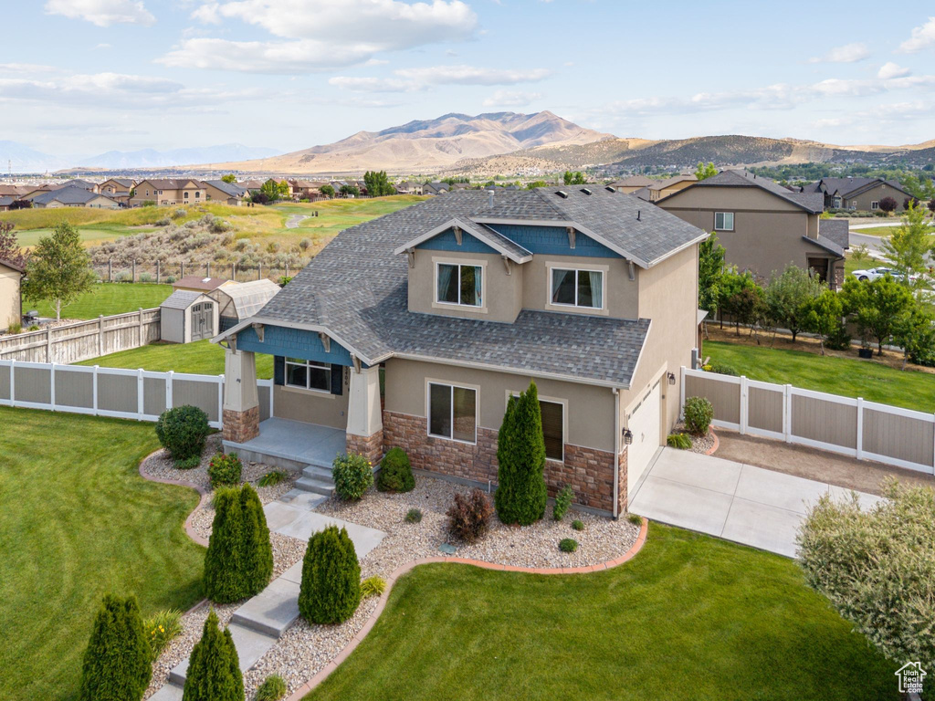View of front of property featuring stucco siding, stone siding, concrete driveway, and a mountain view