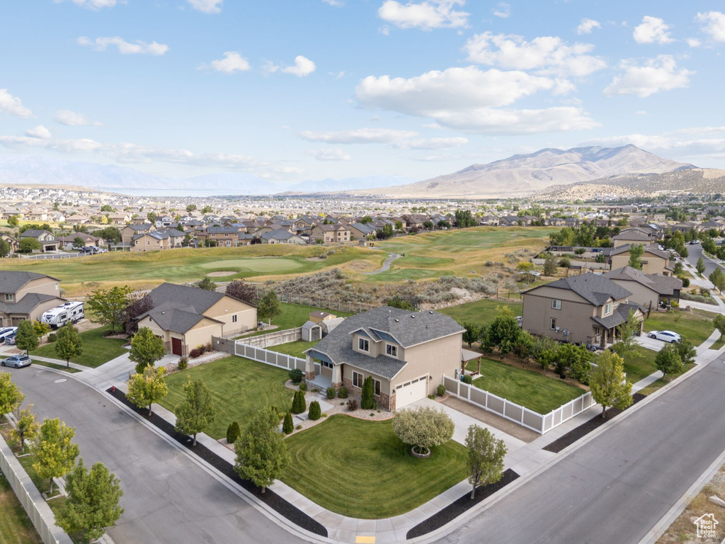 Aerial view of residential area with a mountain backdrop and a golf club