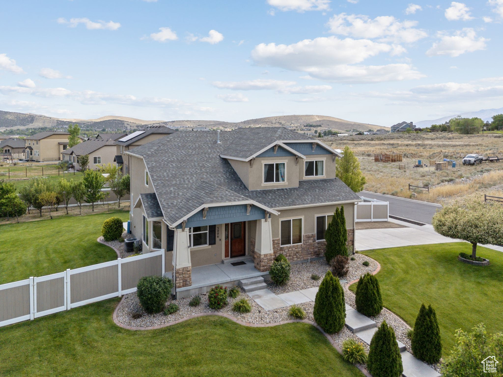 Craftsman house with stone siding, stucco siding, a mountain view, a shingled roof, and a porch