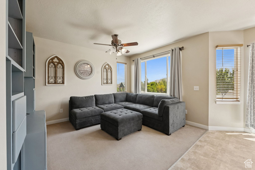 Living room featuring a ceiling fan and light colored carpet