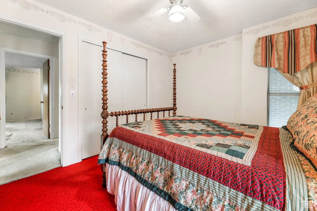 Carpeted bedroom featuring a ceiling fan
