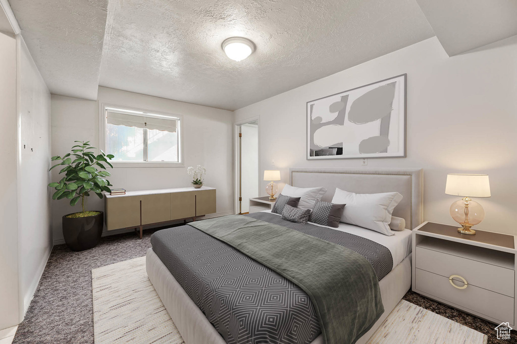 Bedroom featuring a textured ceiling and light carpet