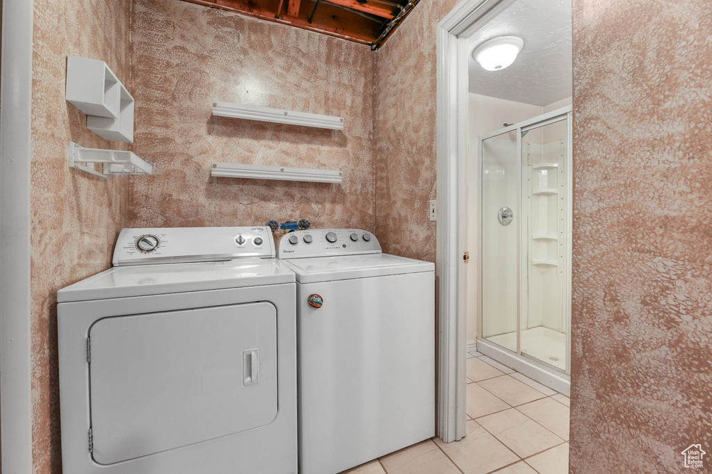 Washroom featuring independent washer and dryer and light tile patterned floors