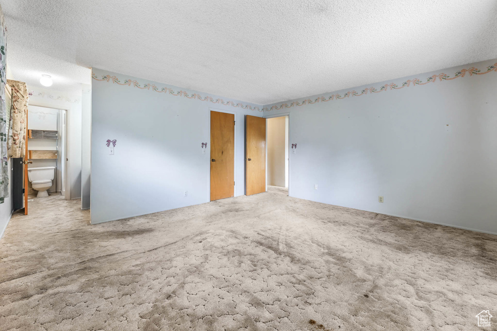 Carpeted empty room featuring a textured ceiling