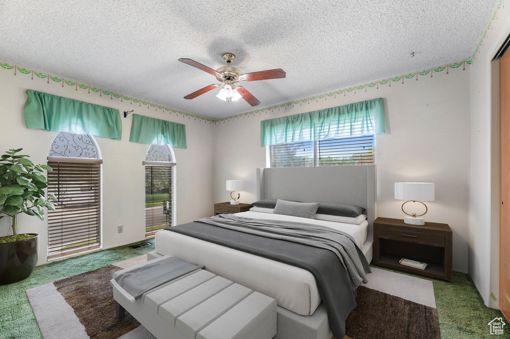 Bedroom with carpet, a textured ceiling, and ceiling fan