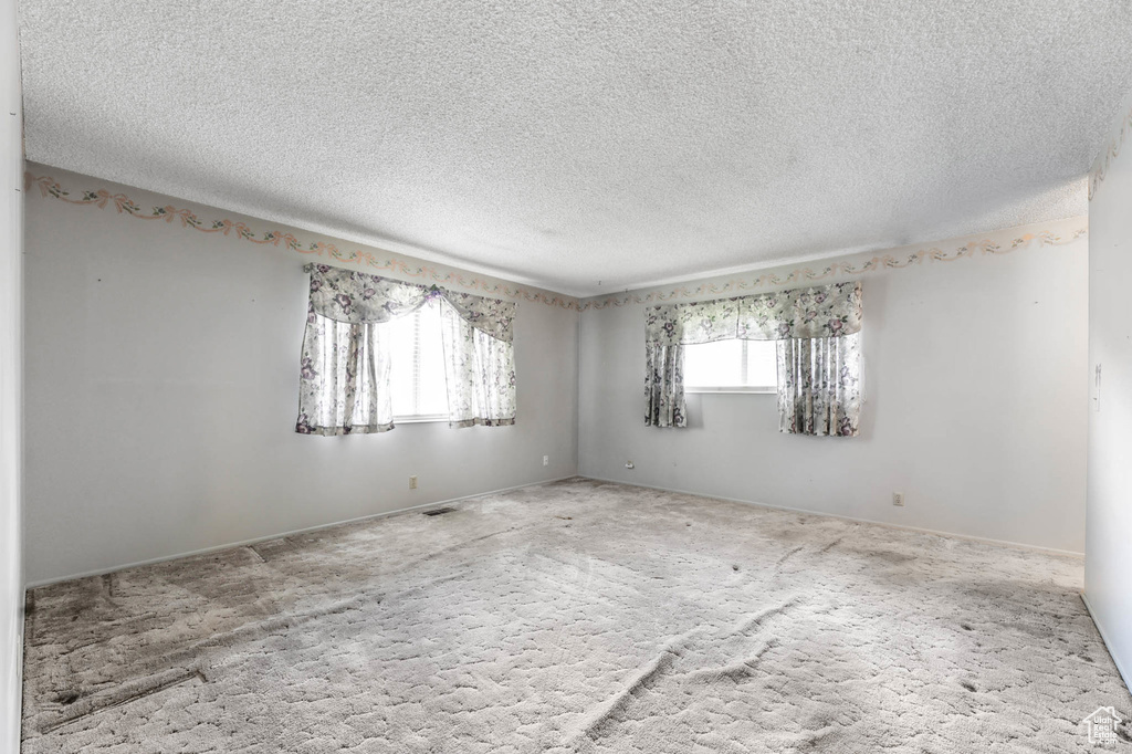 Spare room featuring carpet and a textured ceiling