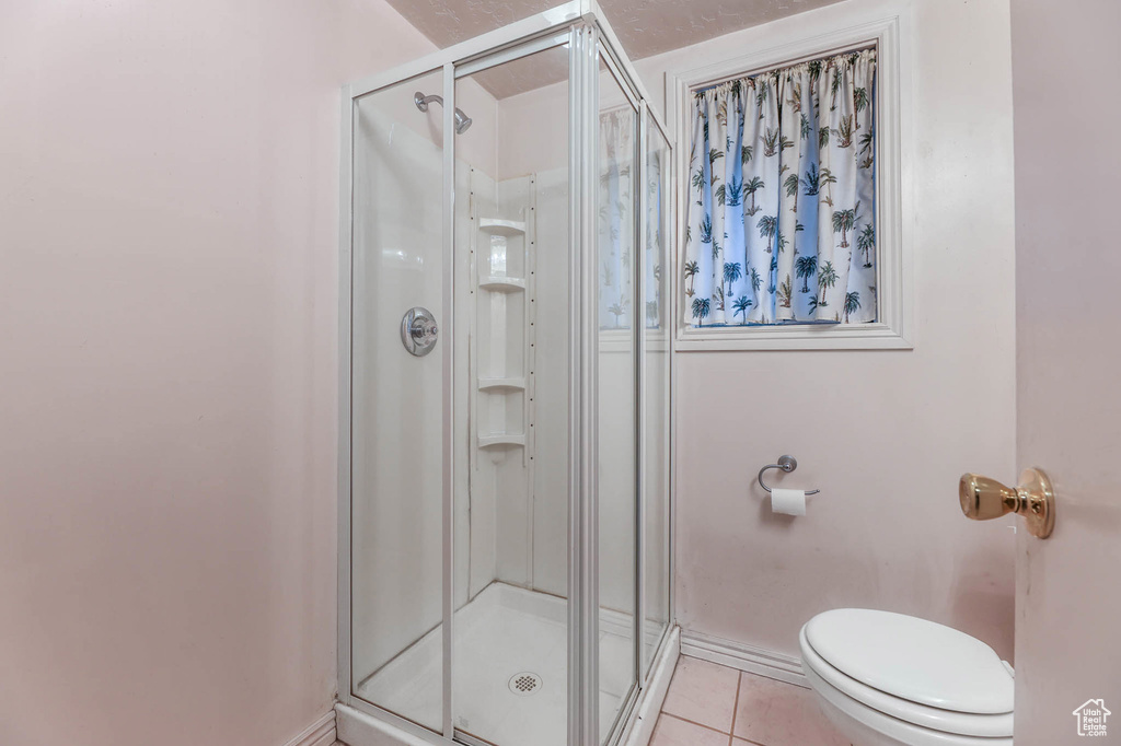 Bathroom featuring tile patterned floors and a stall shower