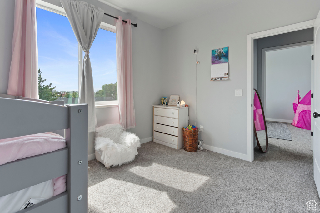 Carpeted bedroom featuring multiple windows