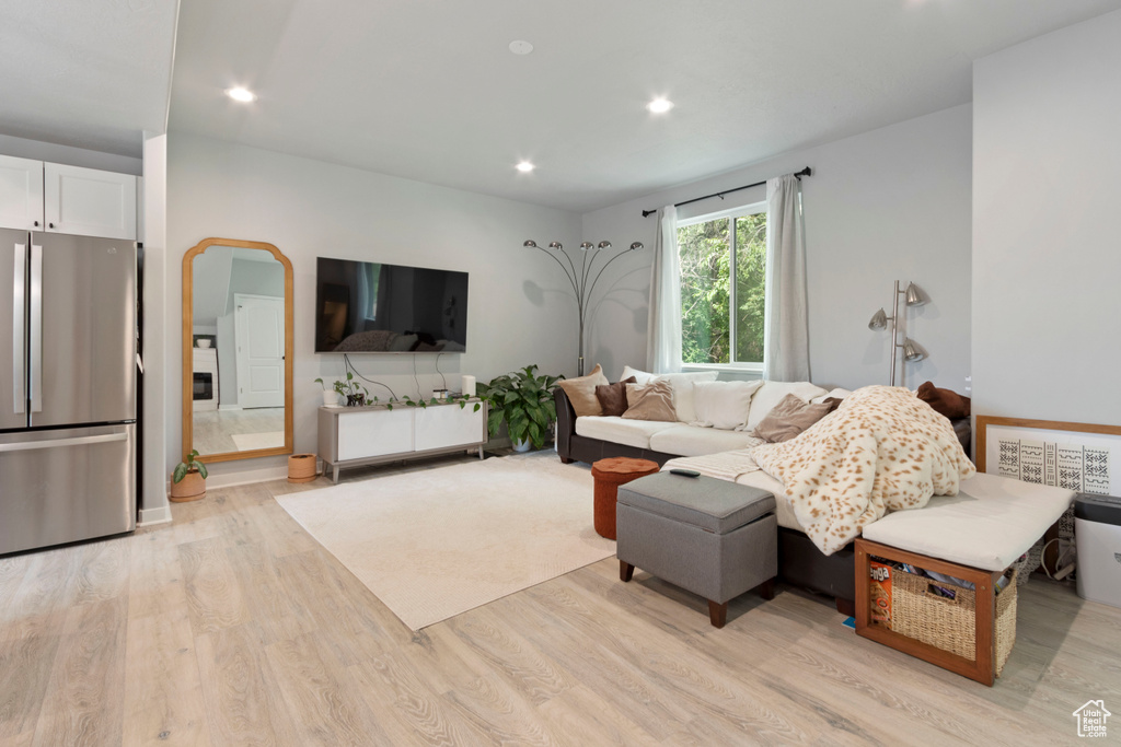 Living room featuring light wood-type flooring, arched walkways, and recessed lighting